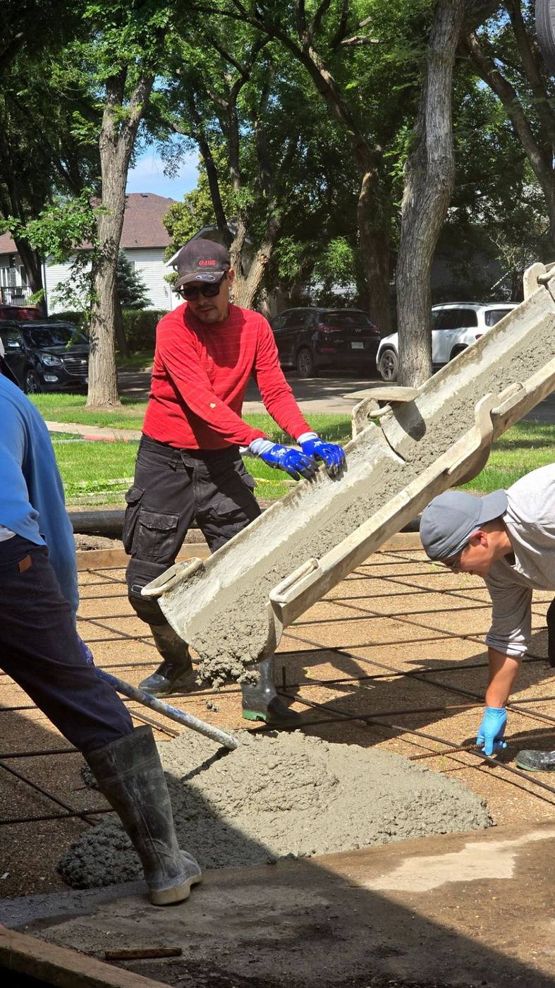Crew directing concrete placement for a foundation and floor pour